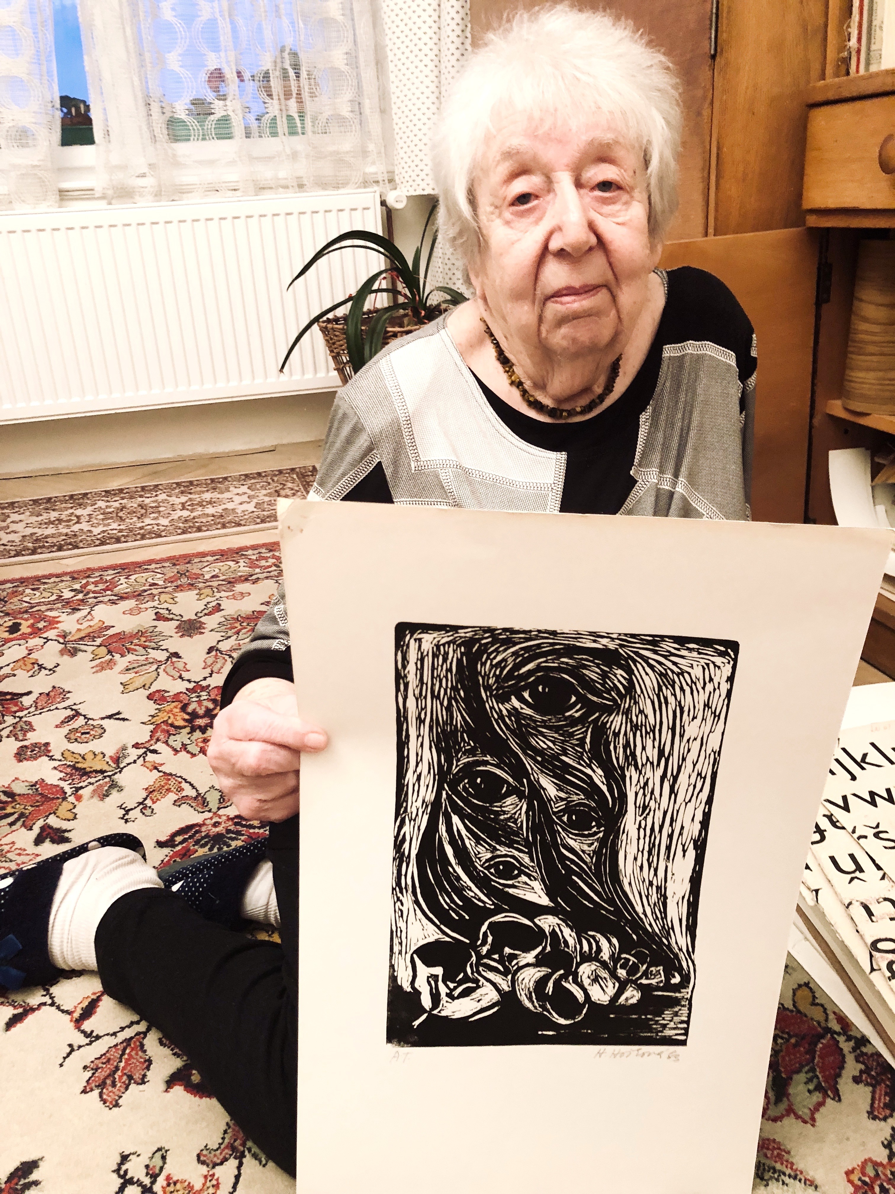 Helga Weissov&aacute; holding one of her prints in her Prague studio