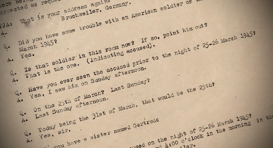 A page of the court-martial testimony at a raking angle, the typed lines falling into shallow focus