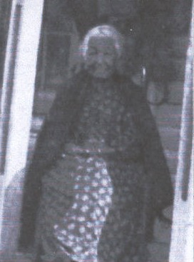 Rachel Bendabout Raincrow, seated in a doorway